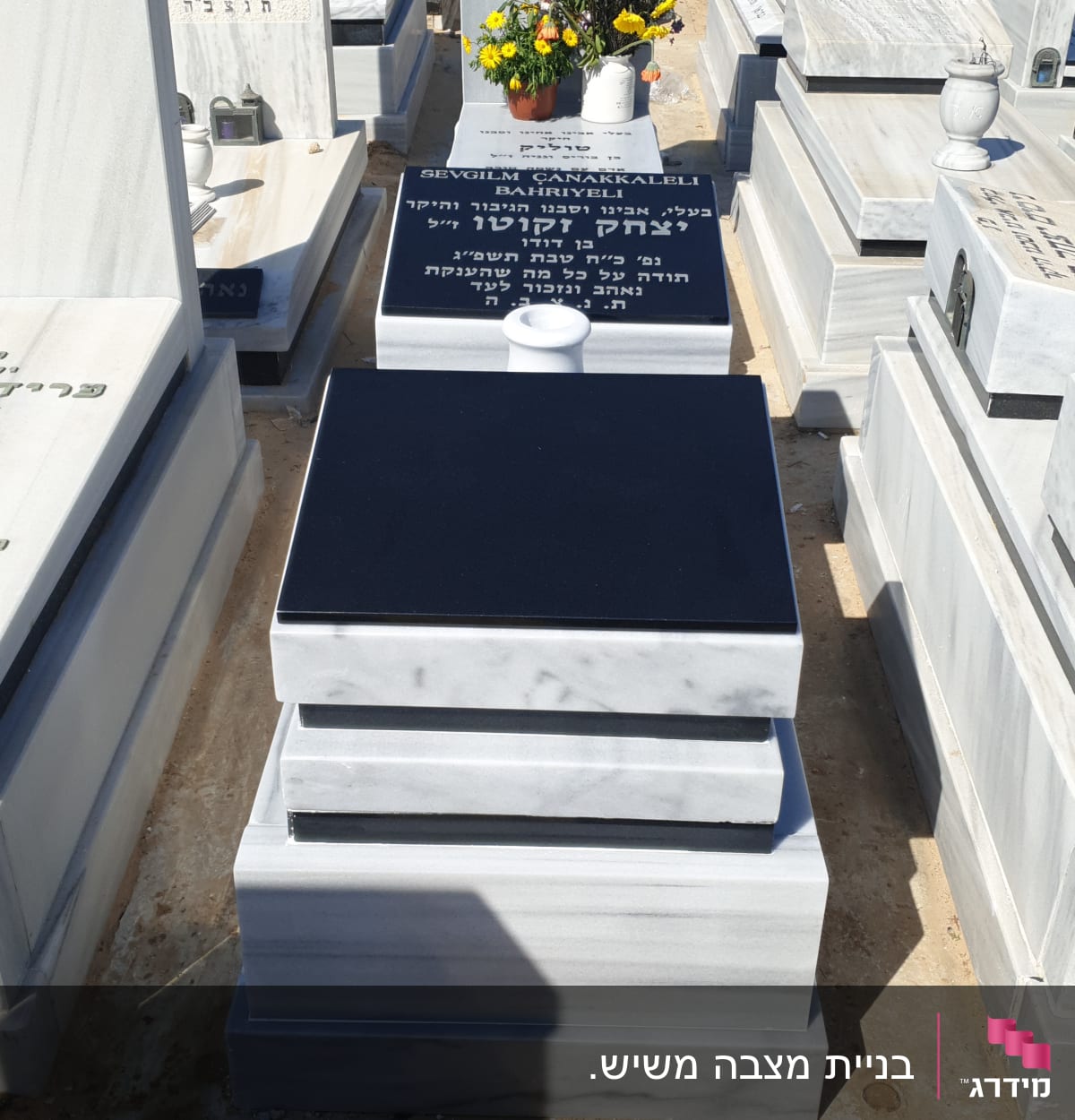 מצבות בבית קברות עם כיתוב ופרחים